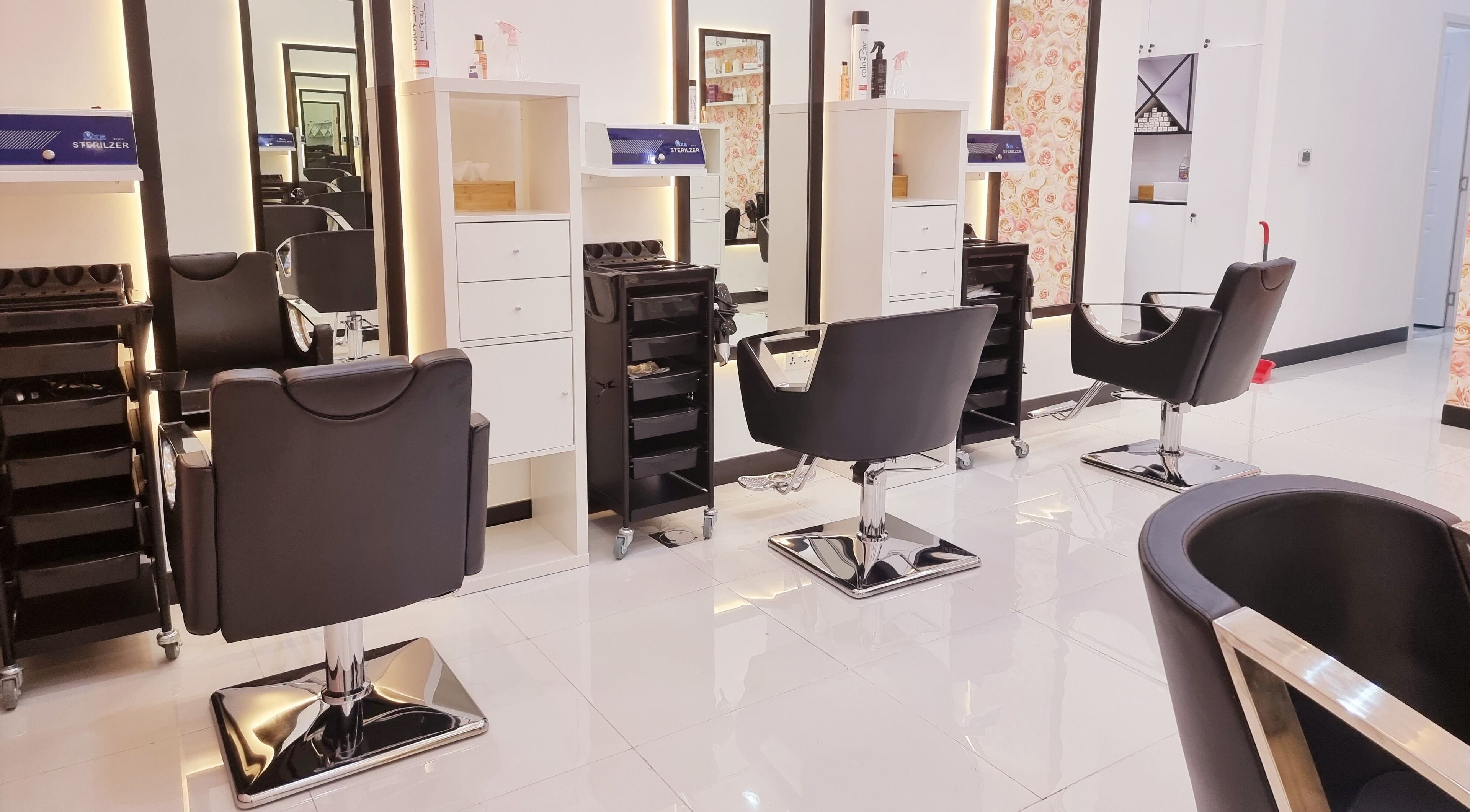 Elegant styling stations at Ombre Salon for Ladies LLC, Dubai, AE, featuring modern black salon chairs.