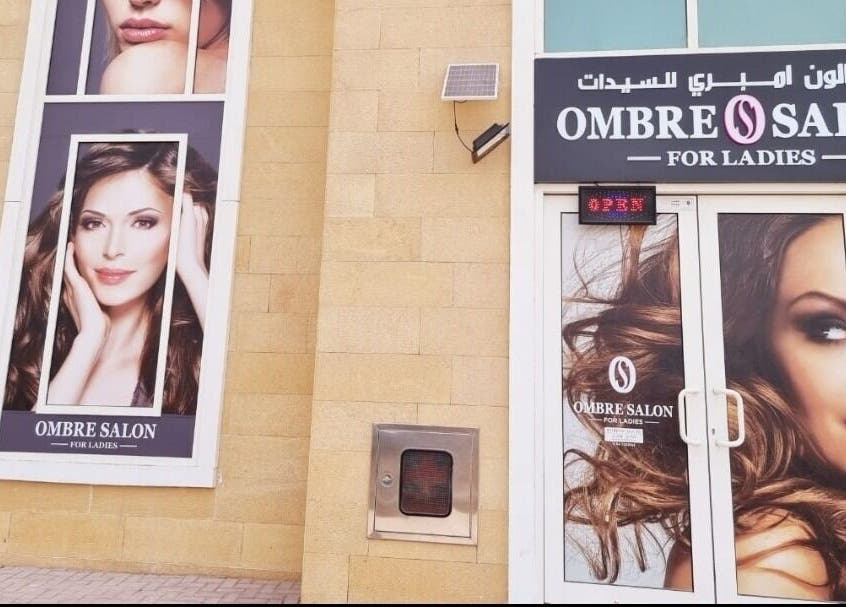 Front view of Ombre Salon for Ladies LLC in Dubai, AE with large beauty posters on the facade.