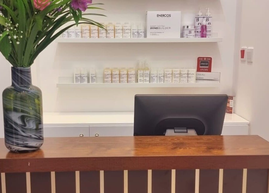 Reception desk at Ombre Salon for Ladies Branch, Dubai, Dubai, AE with products neatly displayed and a floral vase.