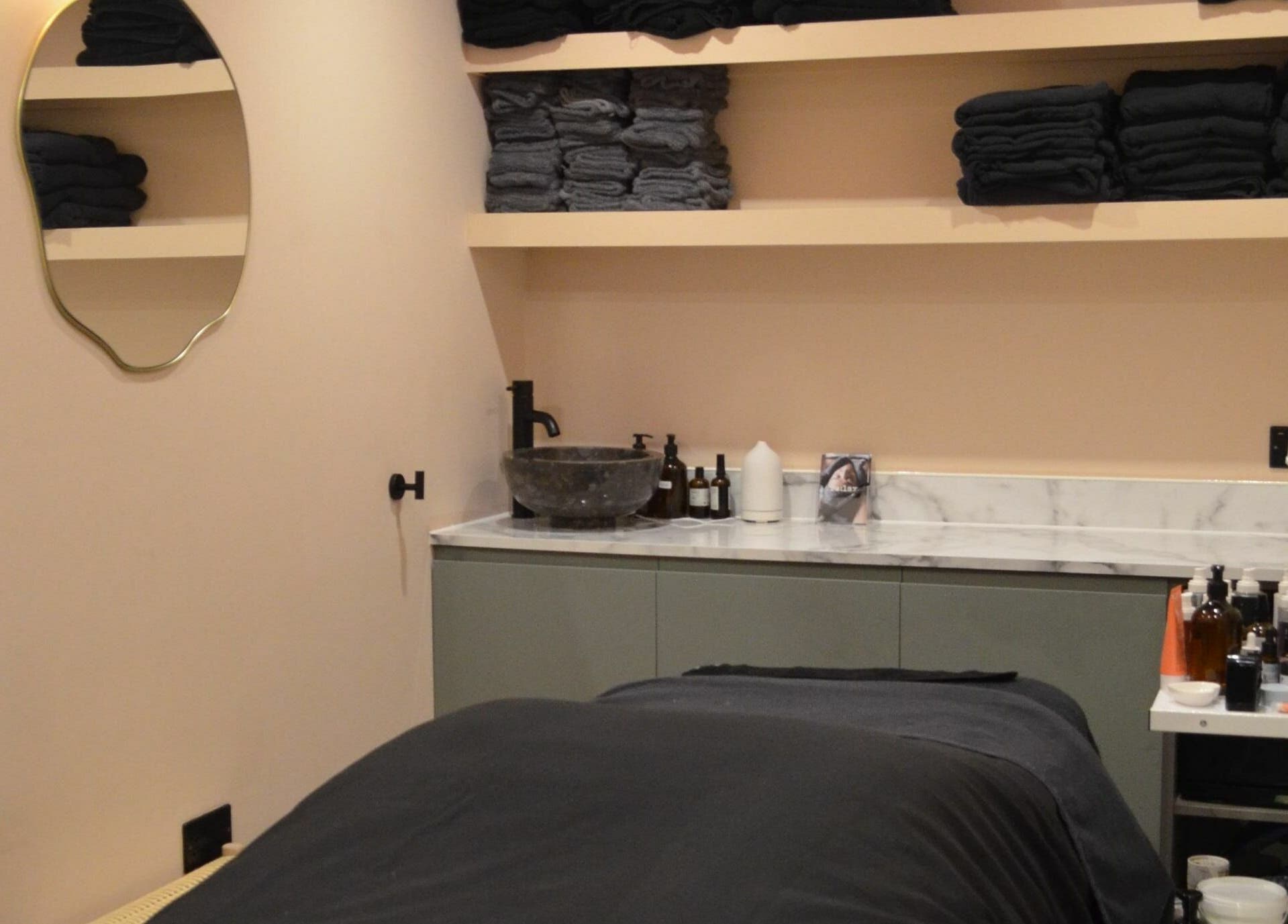 Calming treatment room at re:lax Borough Yards, London, England, GB with towels and skincare products.