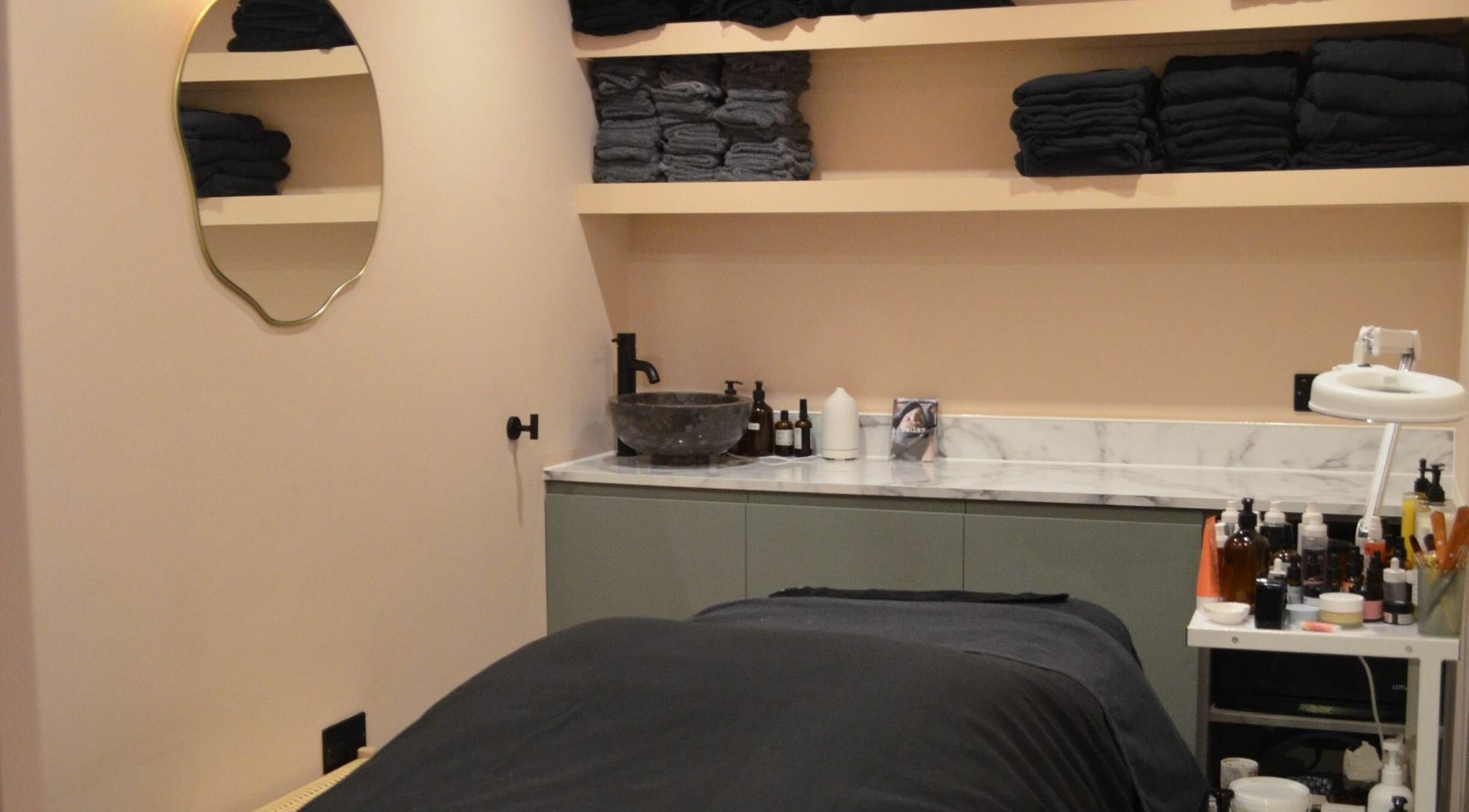 Calming treatment room at re:lax Borough Yards, London, England, GB with towels and skincare products.