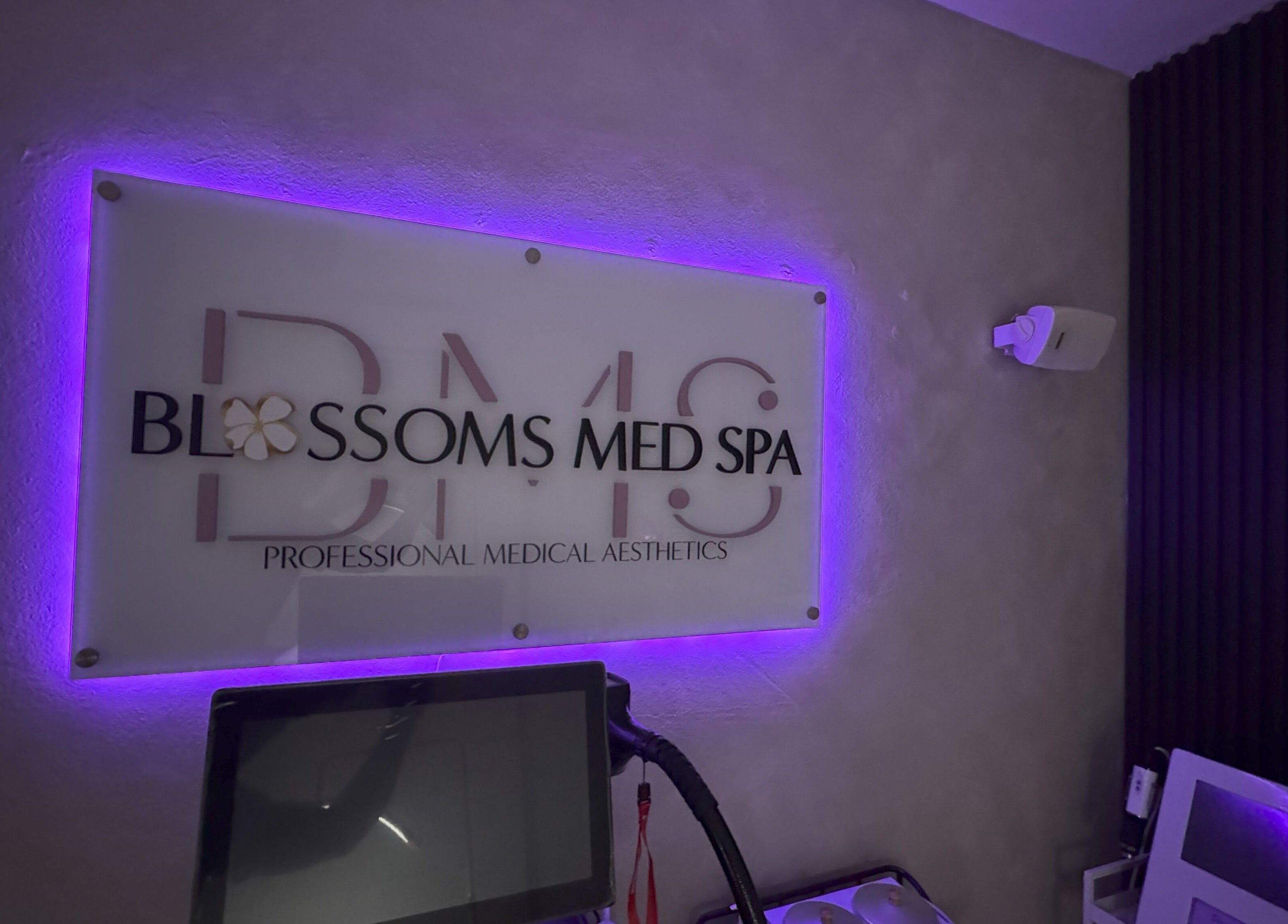 Interior de Blossoms Med Spa Inc iluminado en tono púrpura en Bayamón, US.