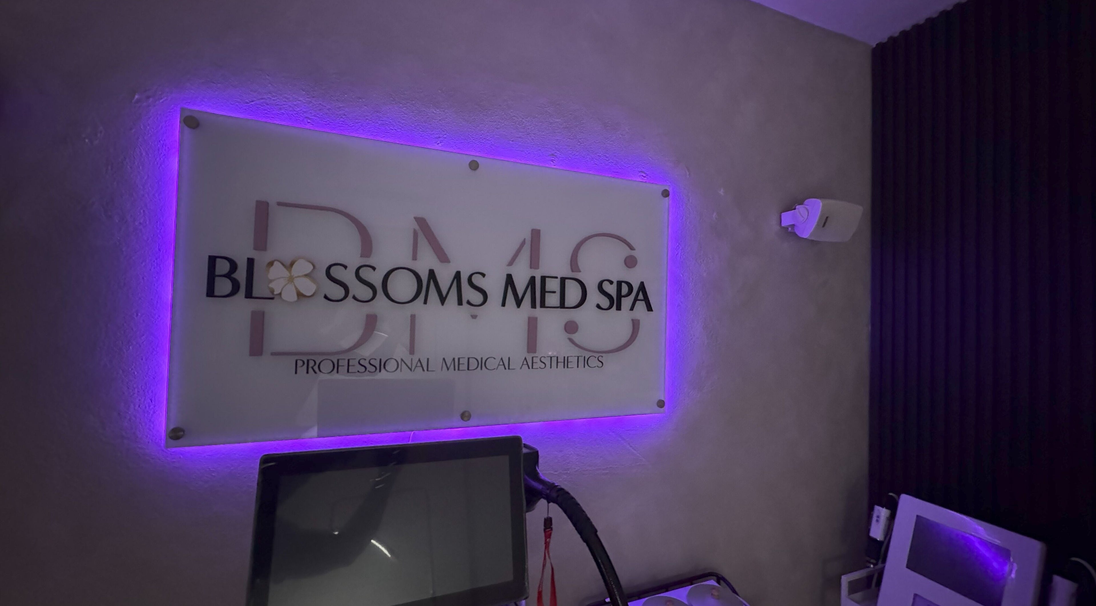 Interior de Blossoms Med Spa Inc iluminado en tono púrpura en Bayamón, US.