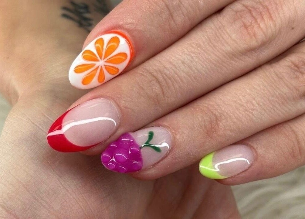 Colorful nail art at Petite Nails and Spa in Chelmsford, Massachusetts, US showcasing fruit designs.