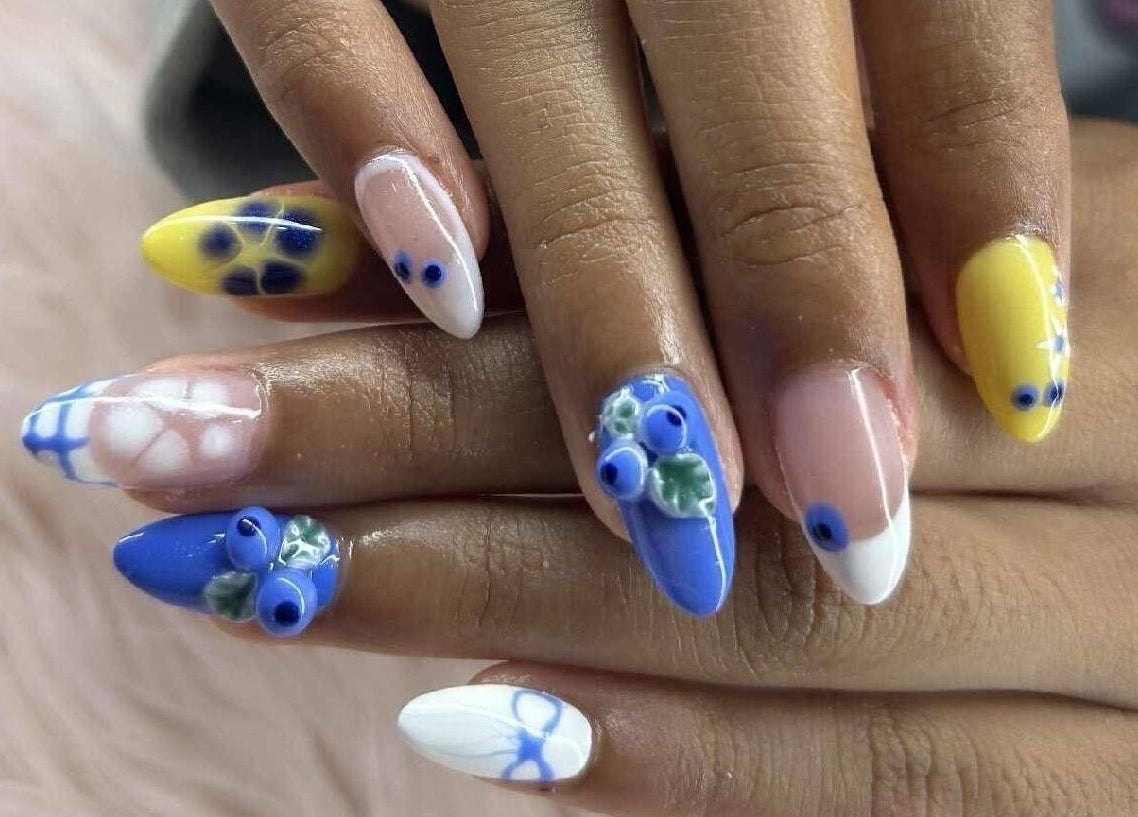 Stylish blue and yellow 3D floral nail art at Petite Nails and Spa, Chelmsford, Massachusetts, US.