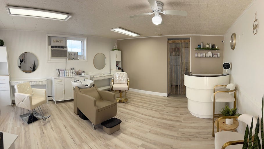 Elegant interior of Elevate Salon Llc in Alpena, Michigan, US featuring modern chairs and shelves with beauty products.