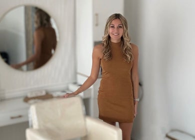 Professional stylist at Elevate Salon Llc, Alpena, Michigan, US, standing beside a mirror in a modern salon.