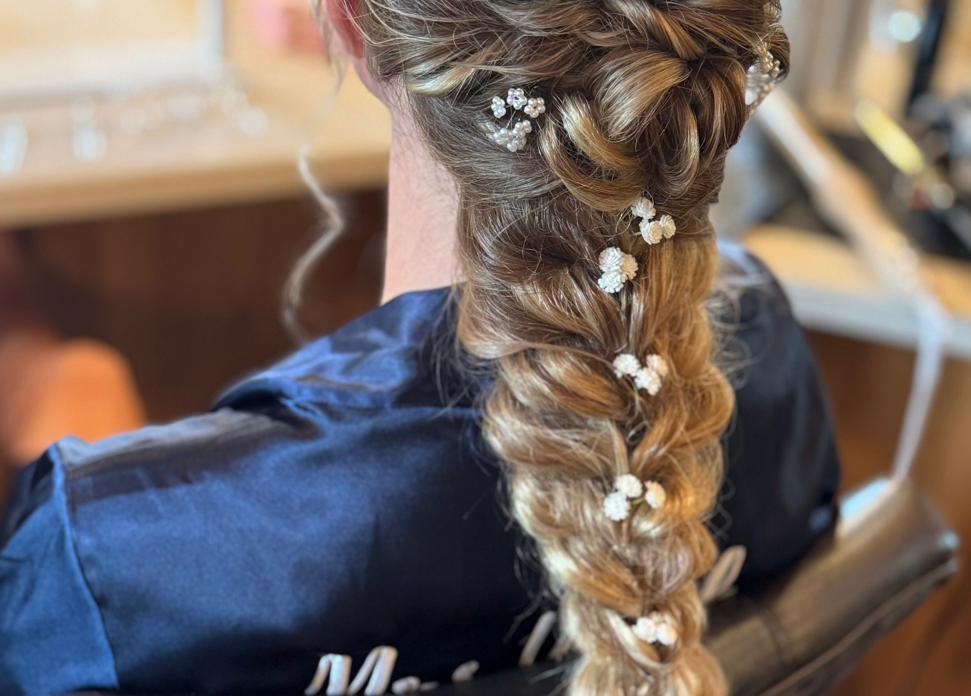 Intricate bridal braid adorned with flowers at Elevate Salon LLC, Alpena, Michigan, US.