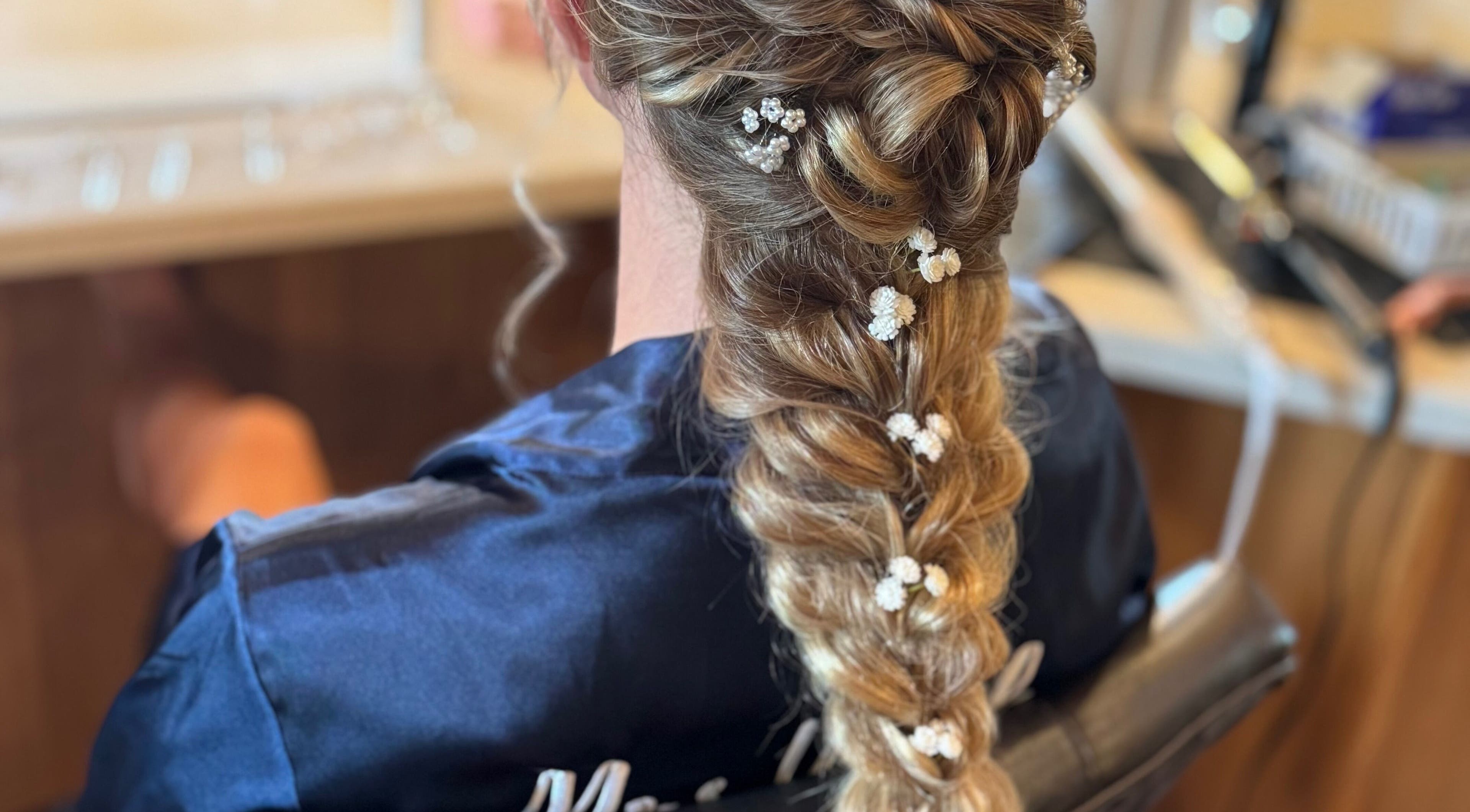Intricate bridal braid adorned with flowers at Elevate Salon LLC, Alpena, Michigan, US.
