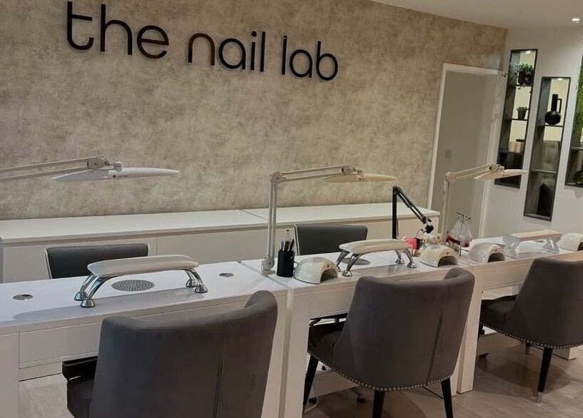 Modern nail salon station at The Nail Lab, Leeds, England, GB with sleek grey chairs and bright lamps.