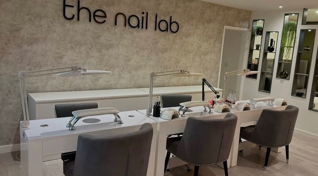 Modern nail salon station at The Nail Lab, Leeds, England, GB with sleek grey chairs and bright lamps.