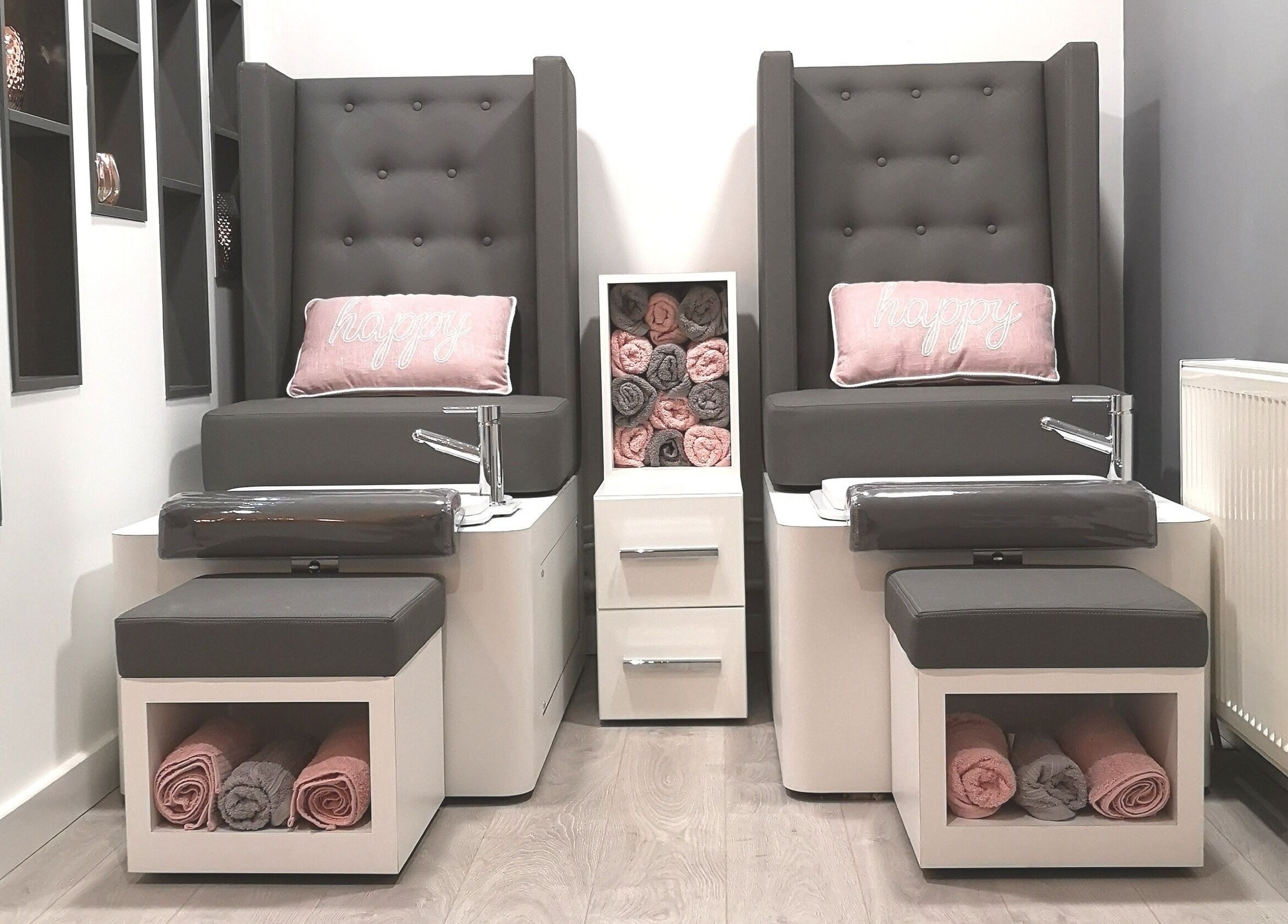 Stylish pedicure chairs with rolled towels at The Nail Lab, Leeds, England, GB. Modern and cozy salon decor.
