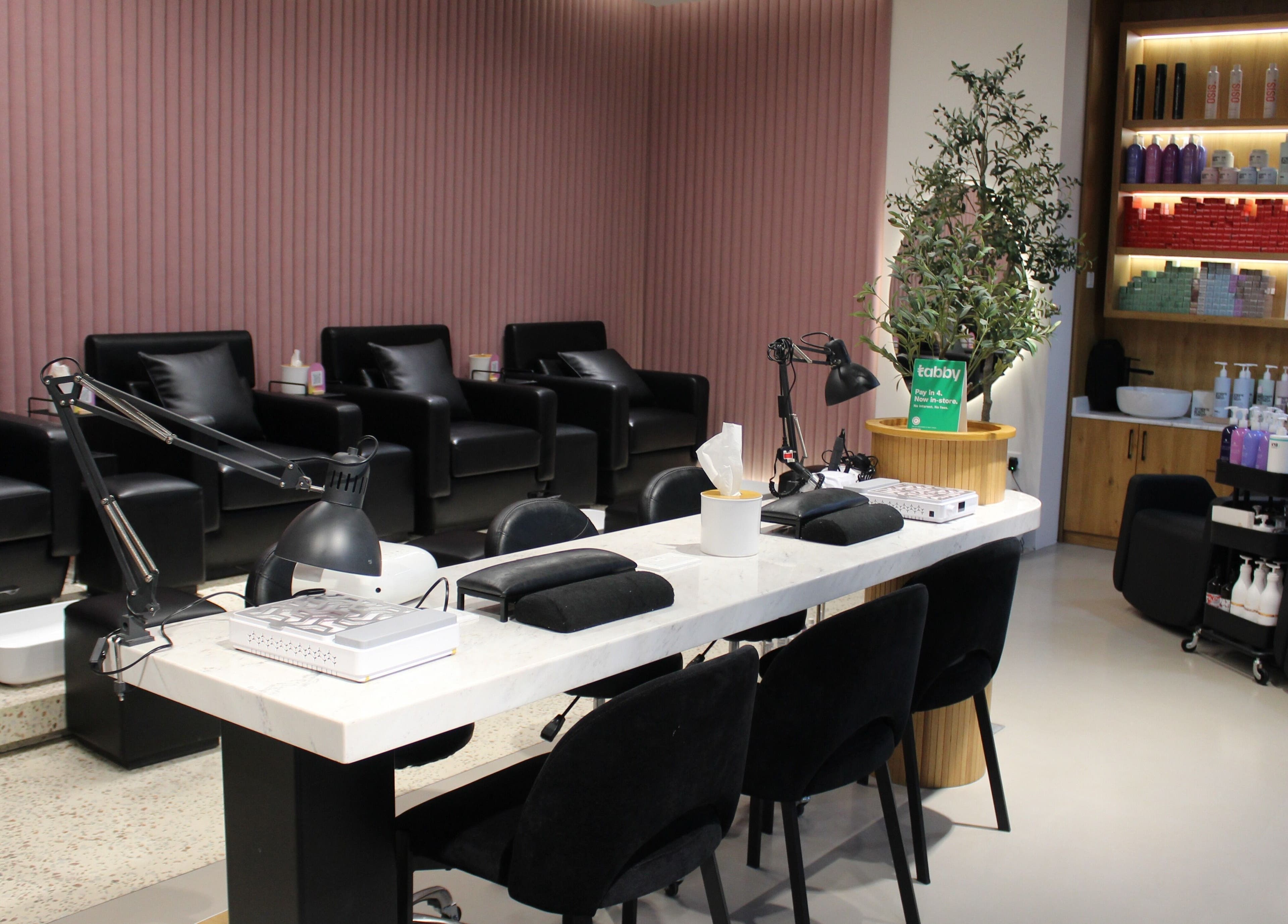 Modern salon interior of The H Ladies Beauty Salon - L.L.C - O.P.C in Abu Dhabi, Abu Dhabi, AE with sleek black chairs.