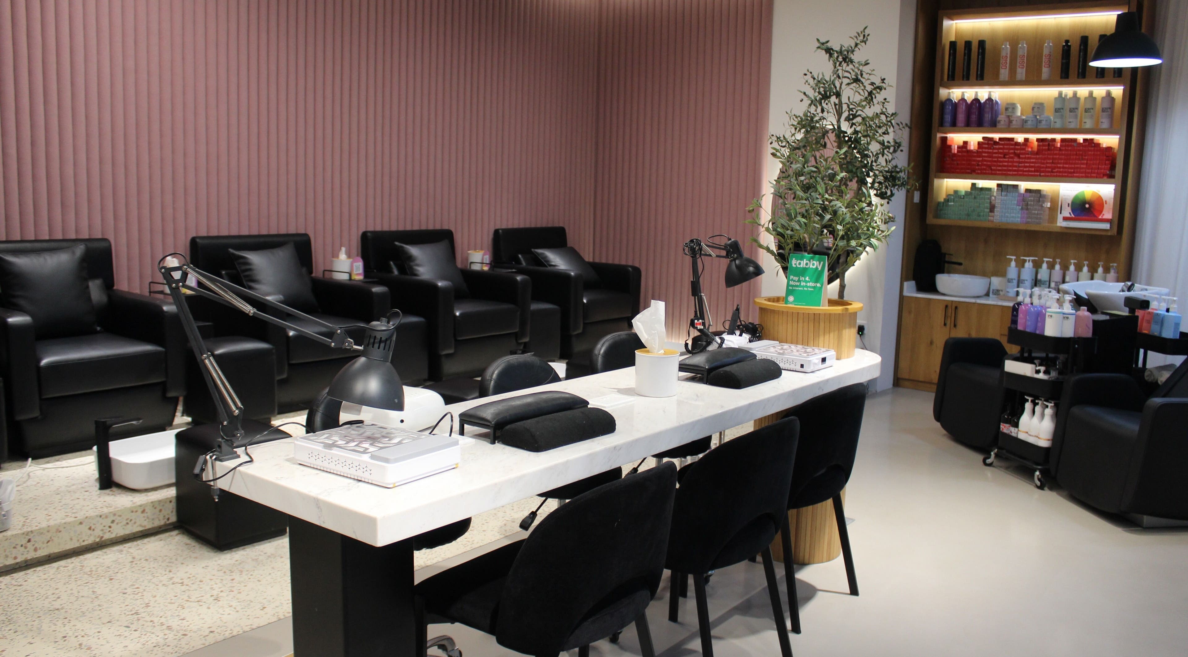 Modern salon interior of The H Ladies Beauty Salon - L.L.C - O.P.C in Abu Dhabi, Abu Dhabi, AE with sleek black chairs.