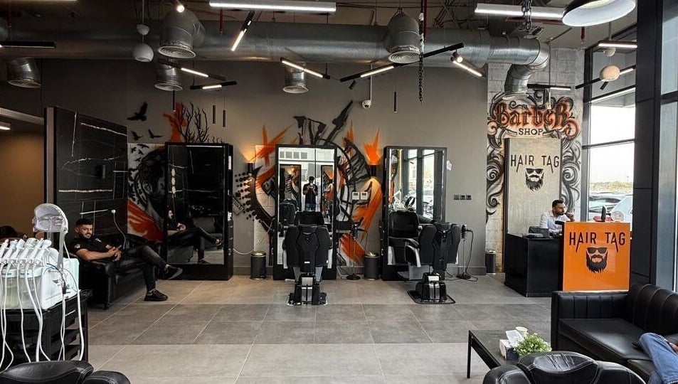 Modern interior of Hair Tag - Al Jaddaf, Dubai, AE with chic barber chairs and graffiti art.