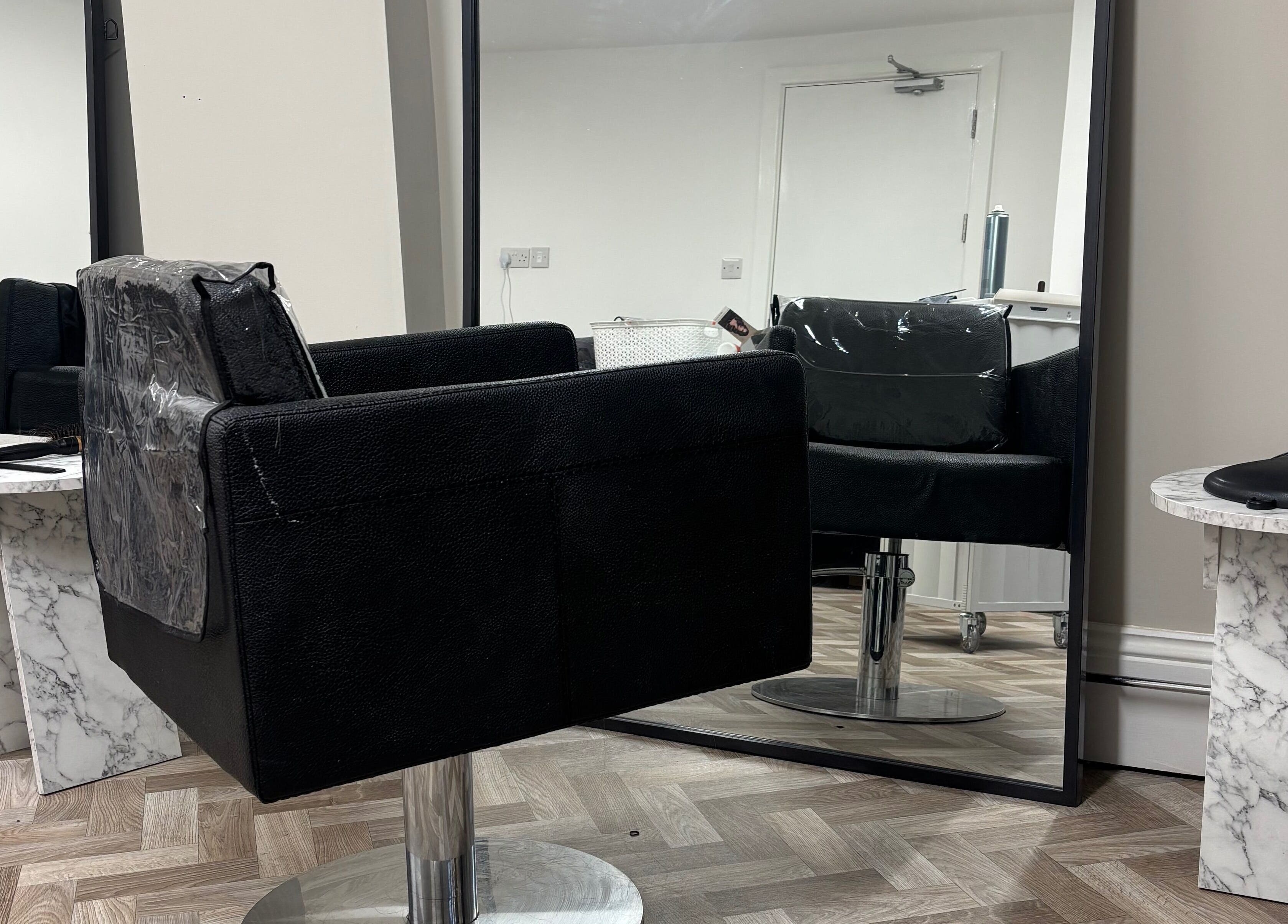 Modern salon chair and mirror at Roxy Hairdressing, Birkenhead, England, GB showcasing chic styling setup.