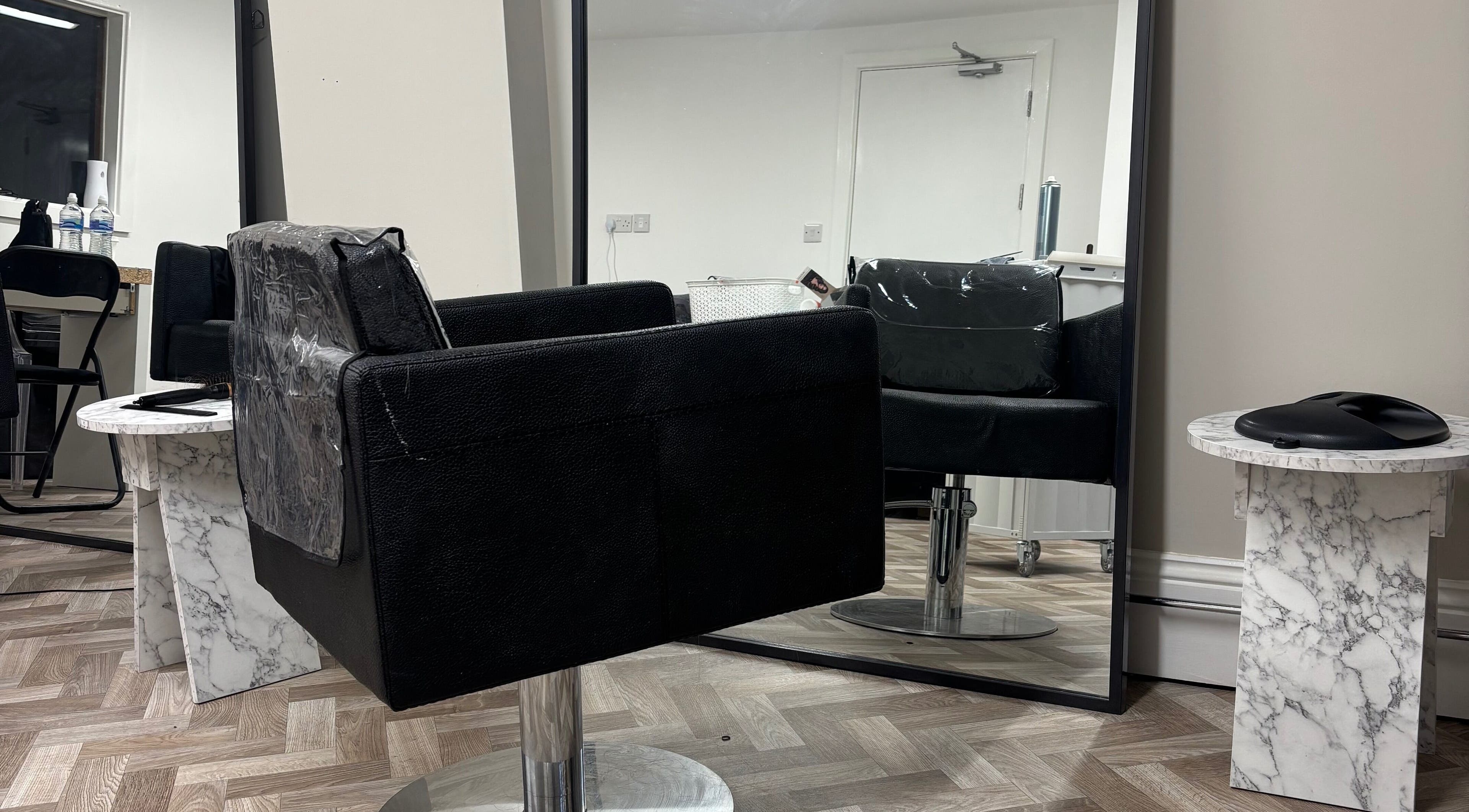 Modern salon chair and mirror at Roxy Hairdressing, Birkenhead, England, GB showcasing chic styling setup.