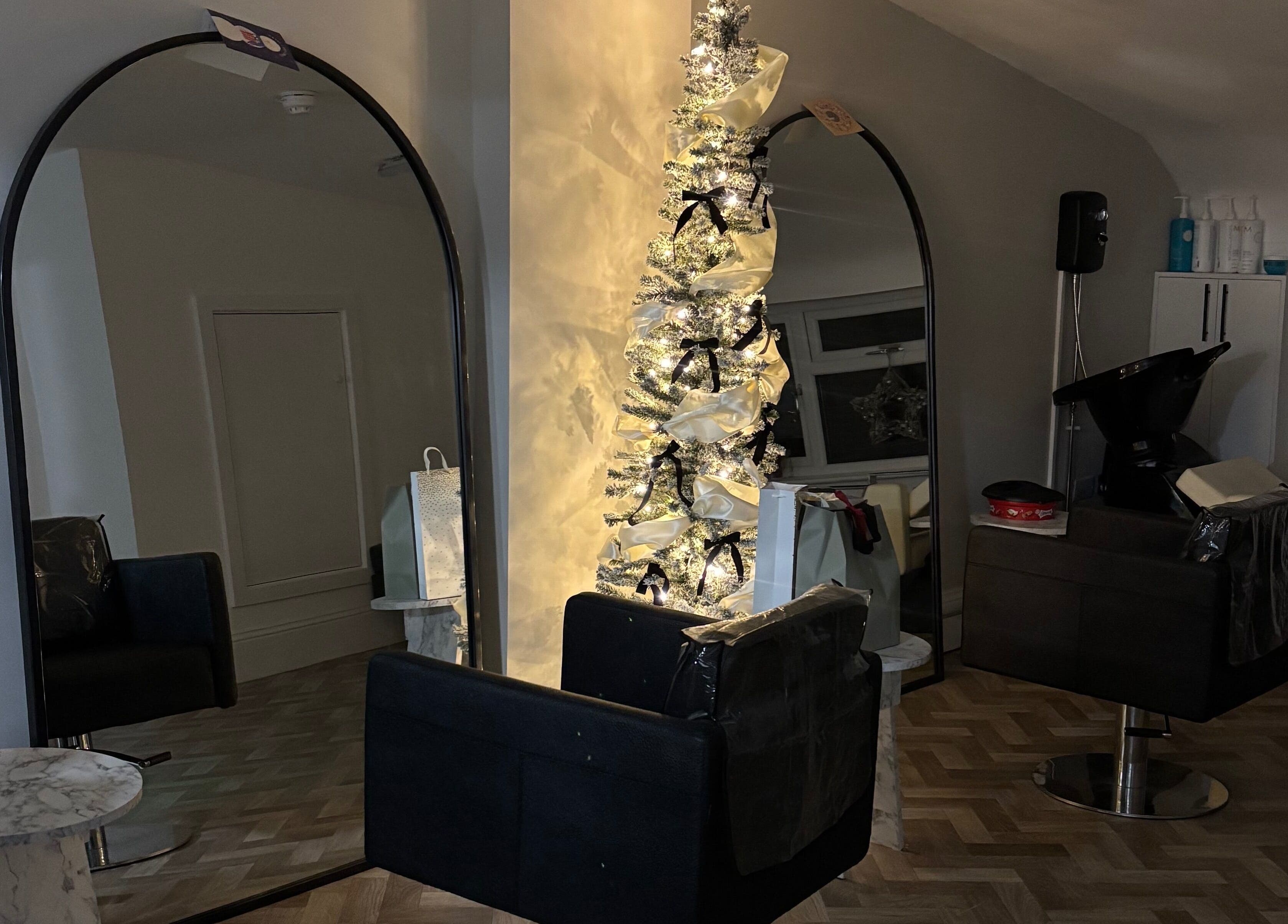 Elegant salon interior with mirrors and festive decor at Roxy Hairdressing, Birkenhead, England, GB.