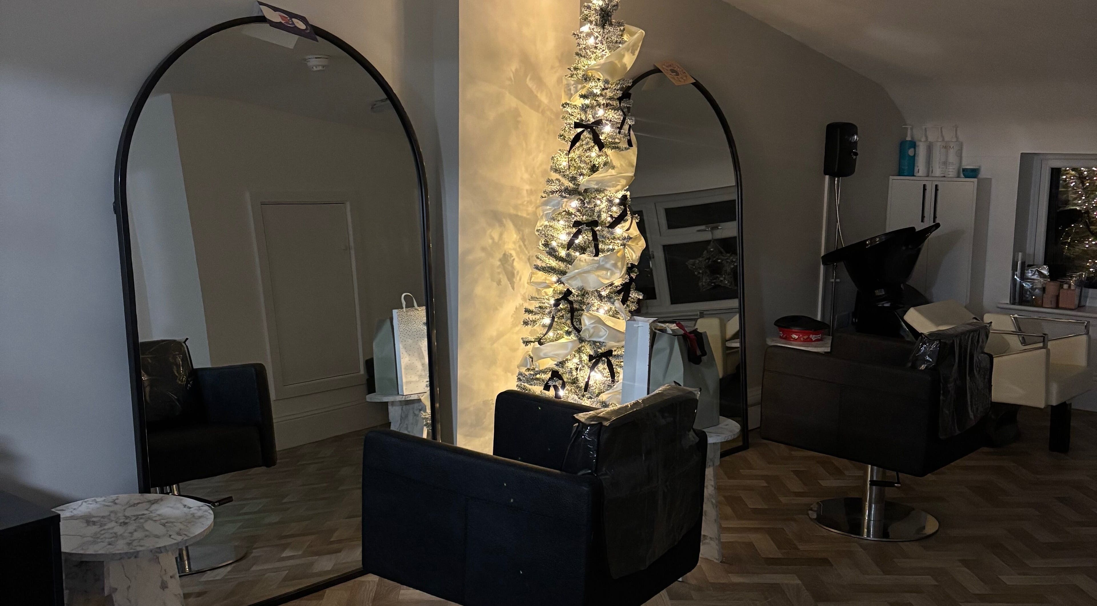 Elegant salon interior with mirrors and festive decor at Roxy Hairdressing, Birkenhead, England, GB.