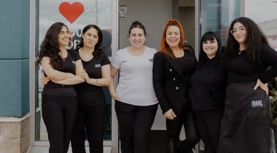 Friendly team of BBare Beauty Bar staff in front of Cambridge, Ontario, CA location welcoming guests.