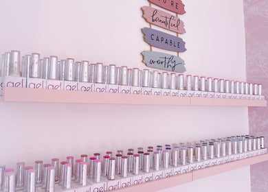 Shelf of vibrant nail polishes at Jessica Lily Beauty, Long Buckby, England, GB, under motivational signs.