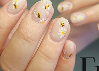 Bee and flower nail art at Enchanted Belle in Boksburg, Gauteng, ZA showcases unique manicure design.
