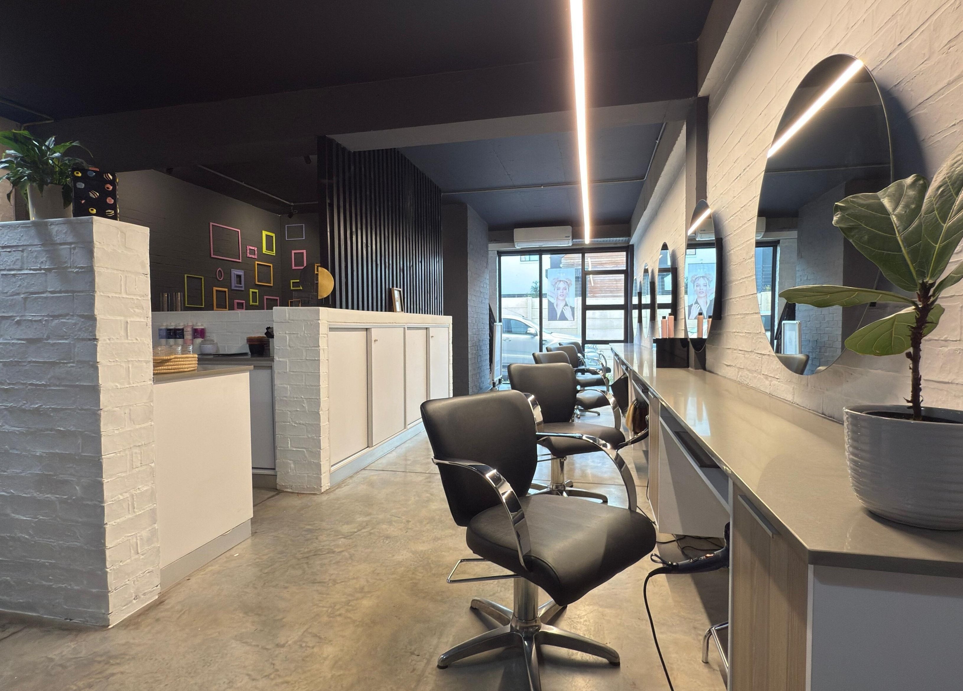 Modern salon interior at The Dome Hair Design in Gqeberha, Eastern Cape, ZA with sleek chairs and mirrors.