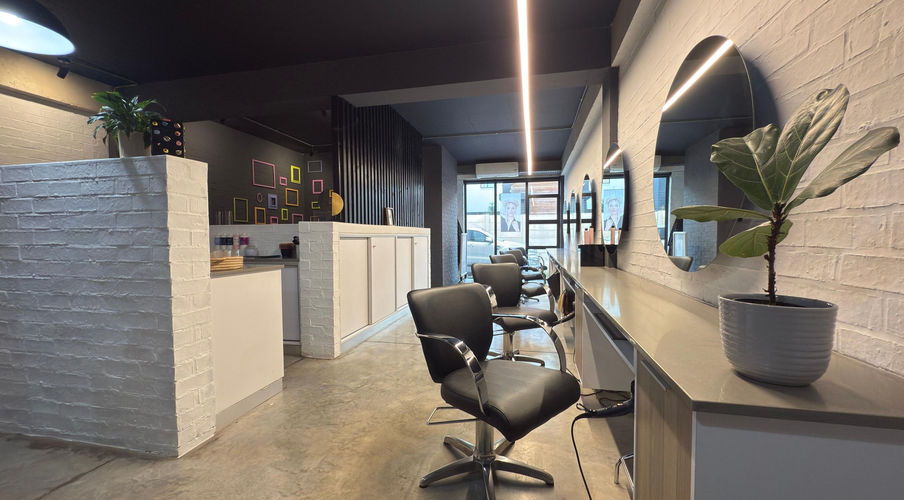 Modern salon interior at The Dome Hair Design in Gqeberha, Eastern Cape, ZA with sleek chairs and mirrors.