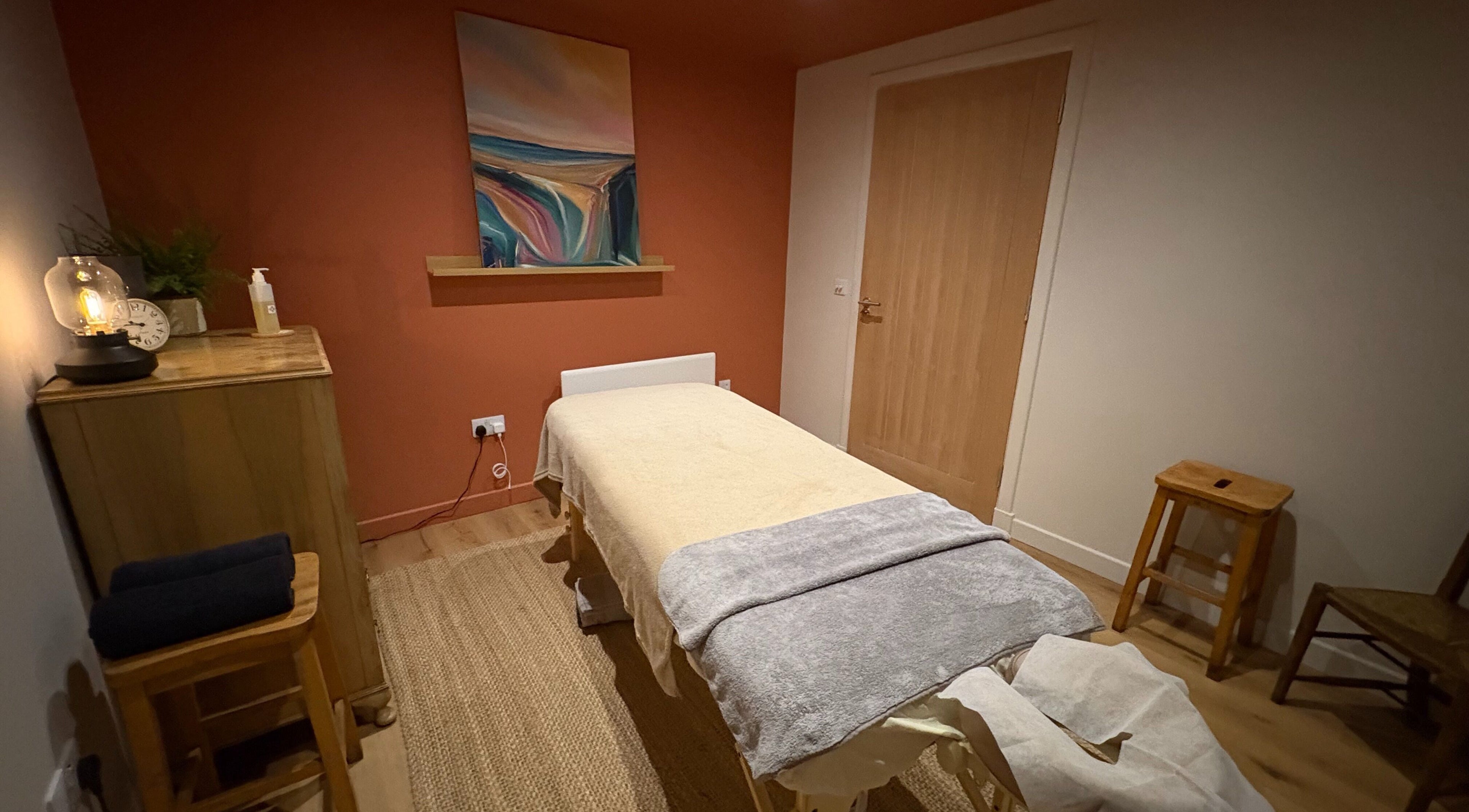 Cozy treatment room at Fois - Fern Bothy, Longniddry, GB with massage table and warm lighting.