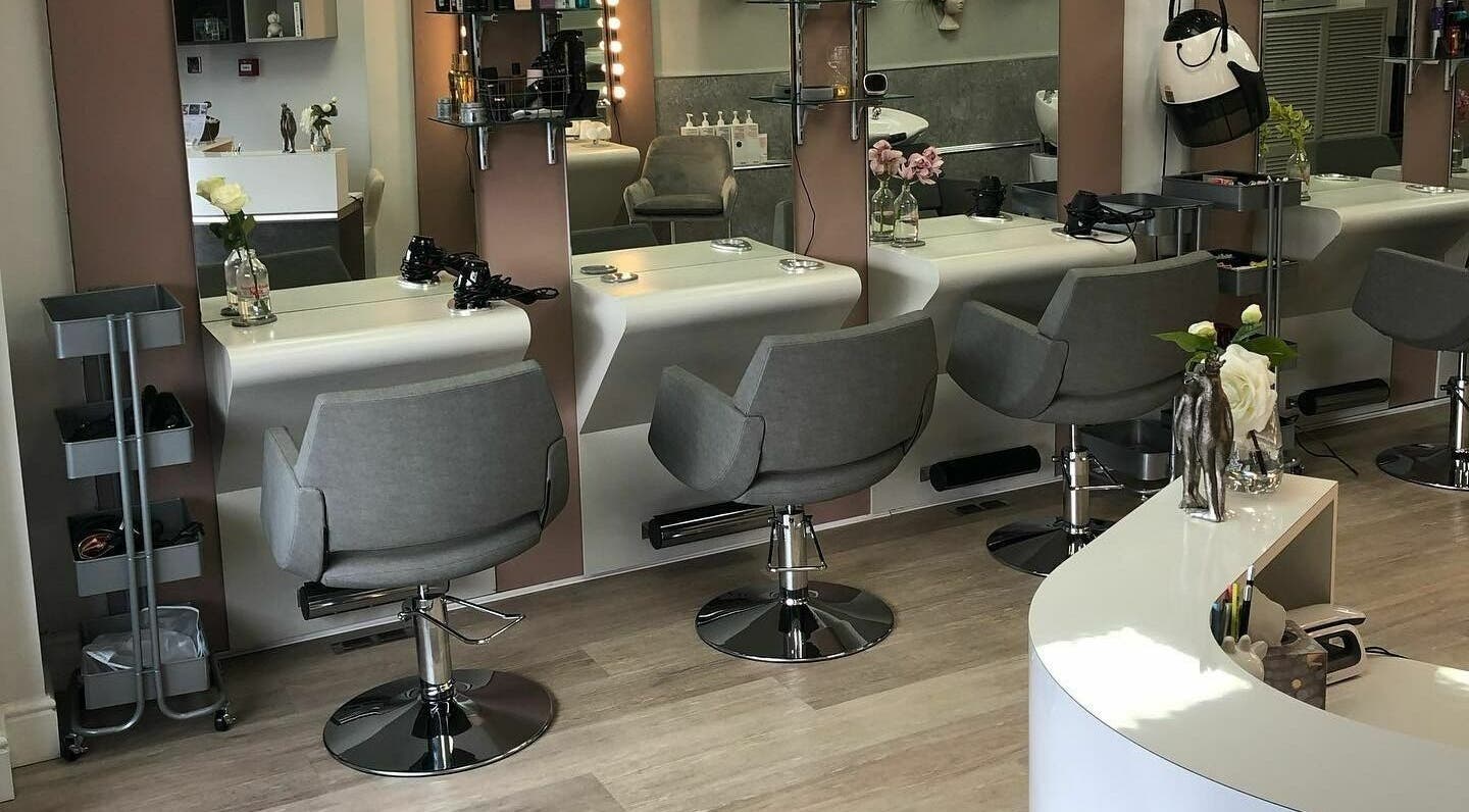 Chic salon interior at The Dollshouse Wollaton, Nottingham, England, GB with stylish chairs and workstations.