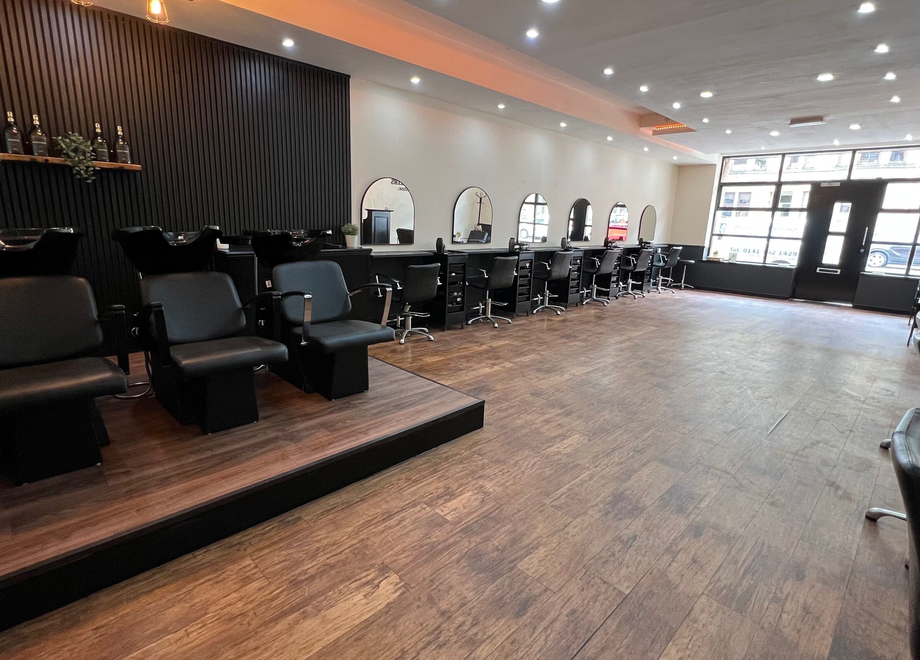 SC Hairdressing in Clydebank, Scotland, GB features a sleek salon interior with black styling chairs and wide mirrors.