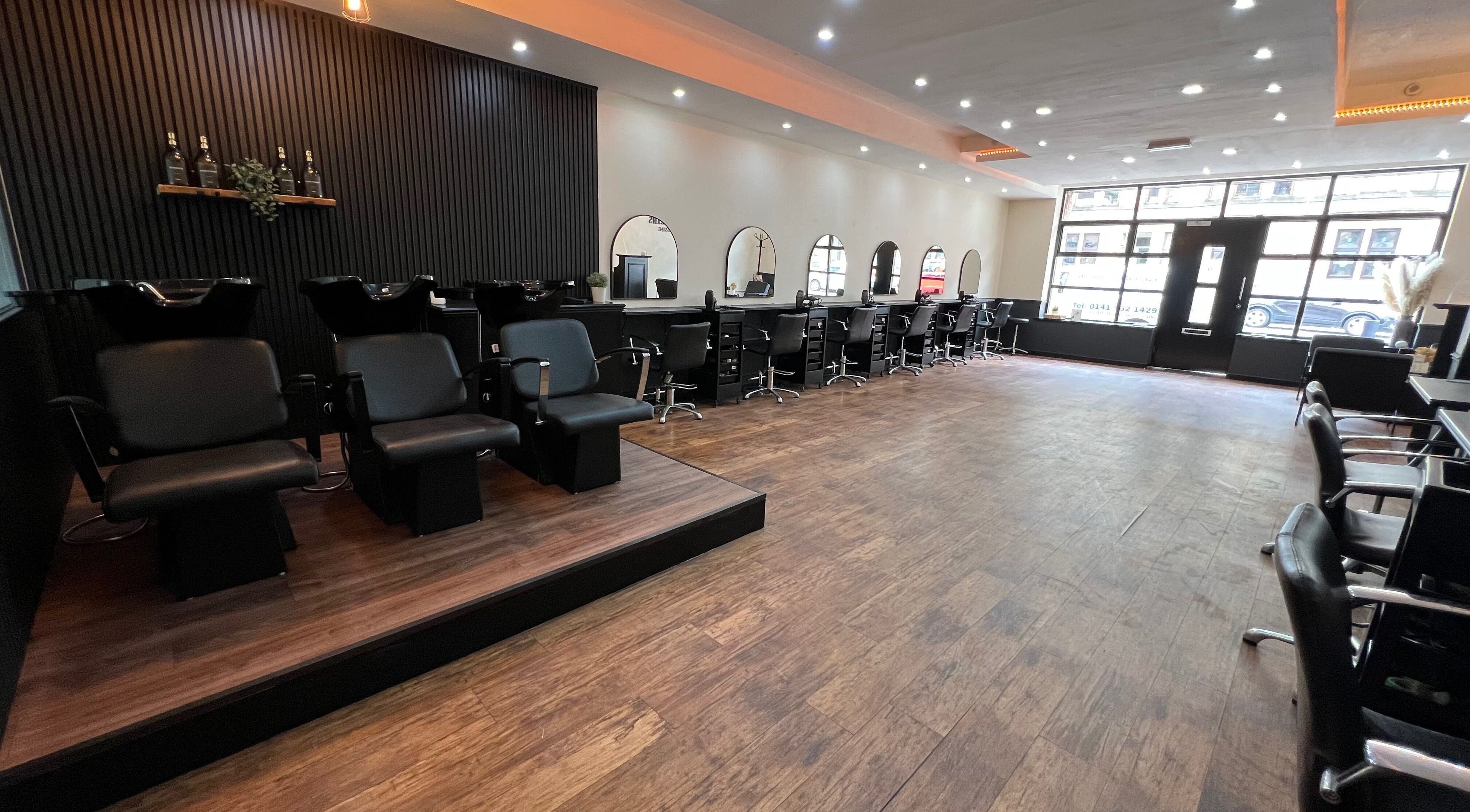 SC Hairdressing in Clydebank, Scotland, GB features a sleek salon interior with black styling chairs and wide mirrors.