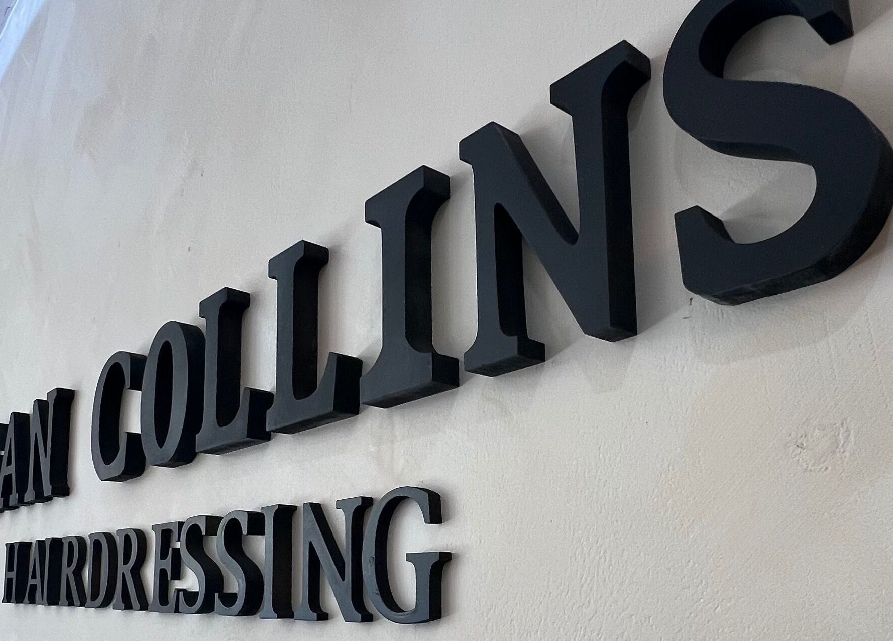 SC Hairdressing signage at Clydebank, Scotland, GB. Bold letters on a textured wall.