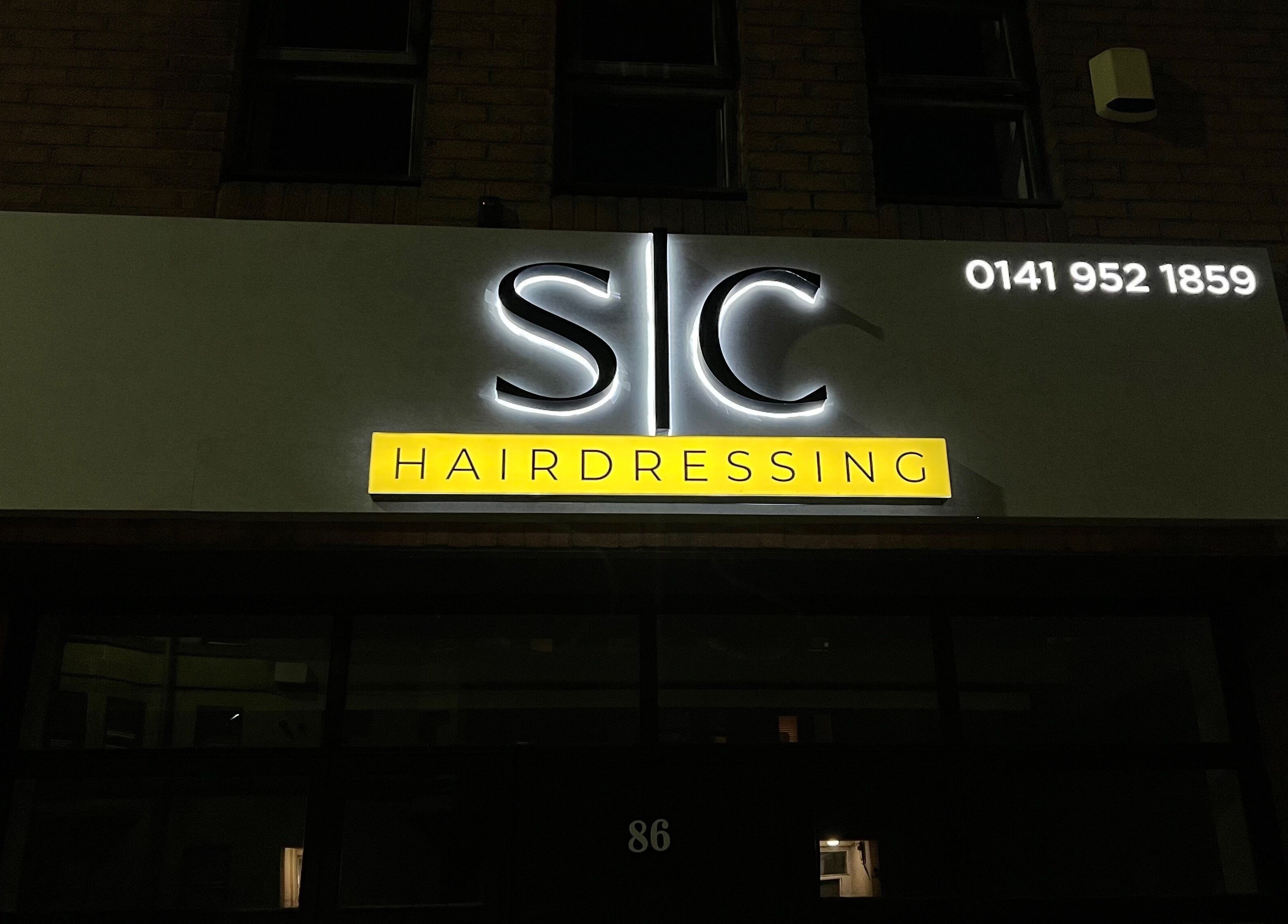 Night view of SC Hairdressing bright signboard at Clydebank, Scotland, GB.