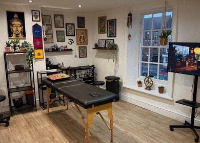 The Black Lotus Studio in Yarm, England, GB, featuring a serene massage room with decor and artwork.