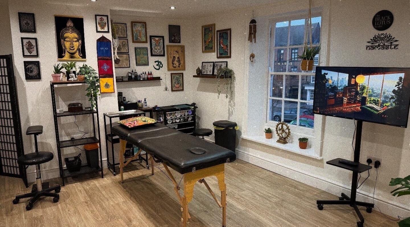 The Black Lotus Studio in Yarm, England, GB, featuring a serene massage room with decor and artwork.