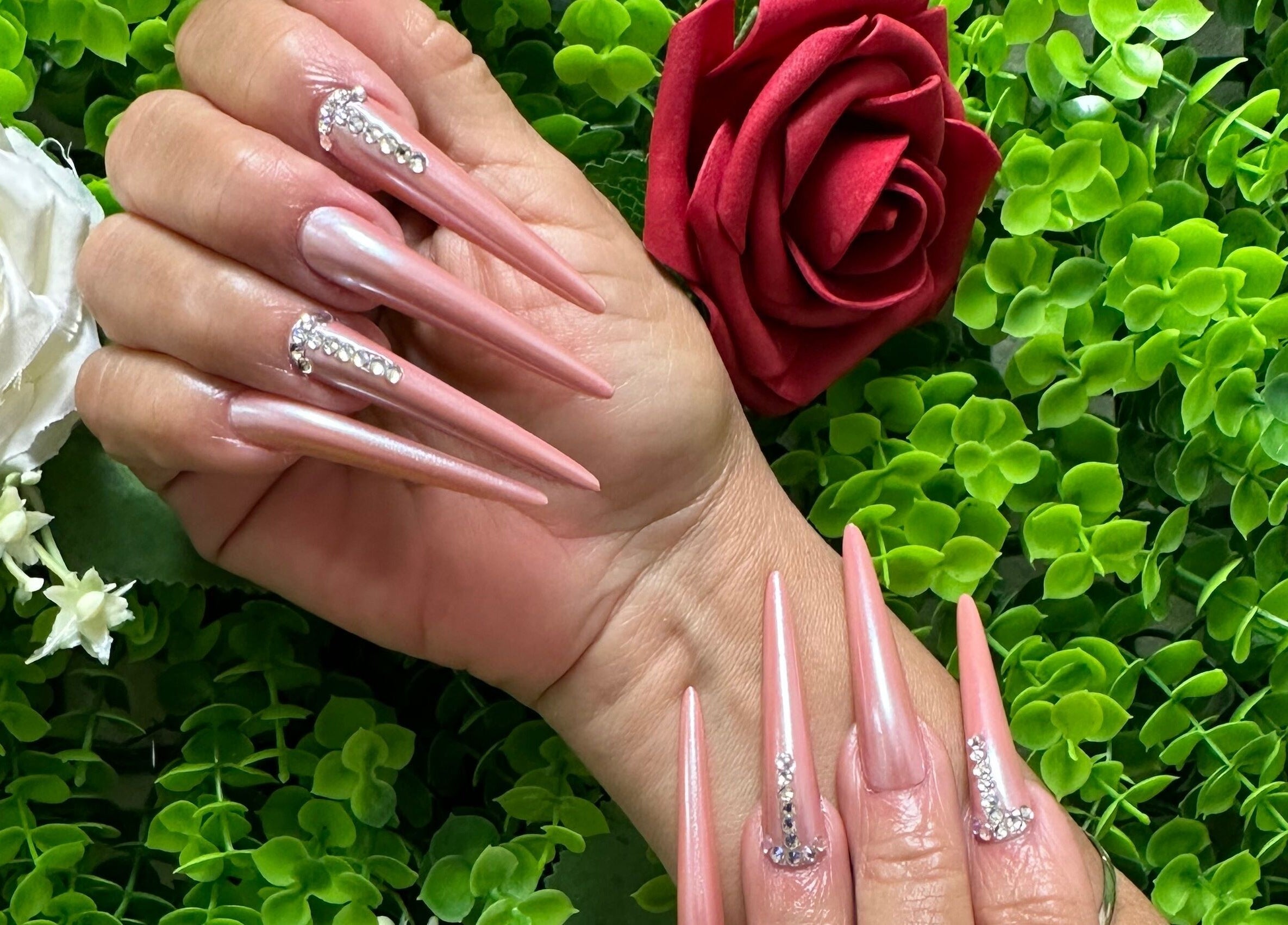 Stunning pink stiletto nails with rhinestones at Lovely Me Nail Studio, Laredo, Texas, US.