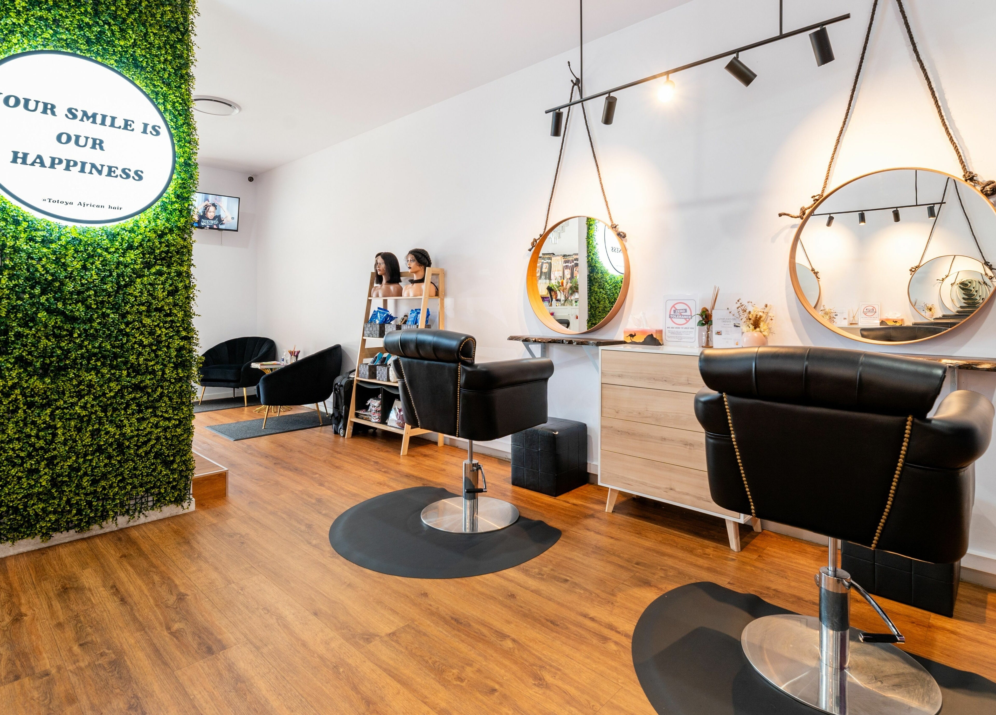 Stylish salon interior at Totoya African Hair, Richlands, Queensland, AU with modern chairs and decorative mirrors.