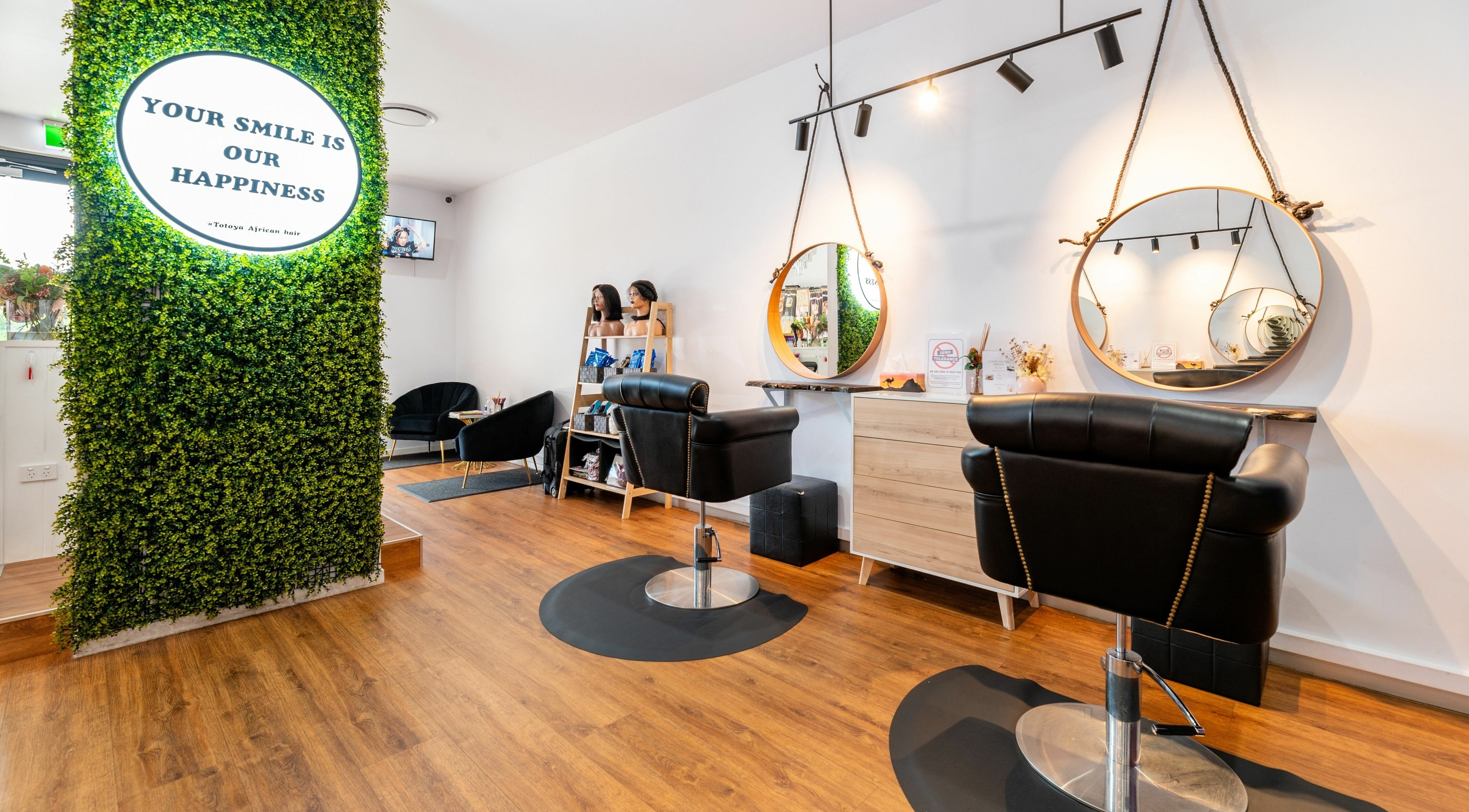 Stylish salon interior at Totoya African Hair, Richlands, Queensland, AU with modern chairs and decorative mirrors.