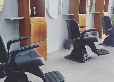 Modern interior of Volume Gents Salon, Dubai, AE with sleek black salon chairs and wooden mirrors.