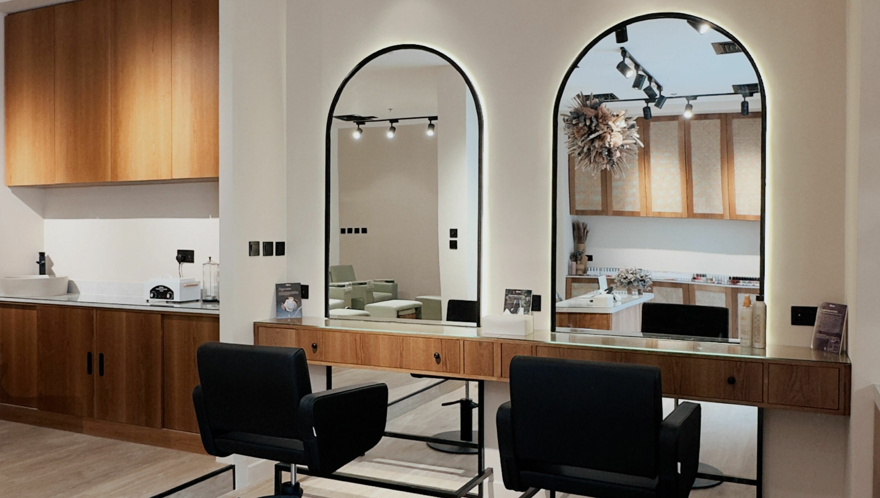 Modern salon setup at Snob Salon Arjan, دبي, دبي, AE featuring sleek wooden décor and stylish mirrors.