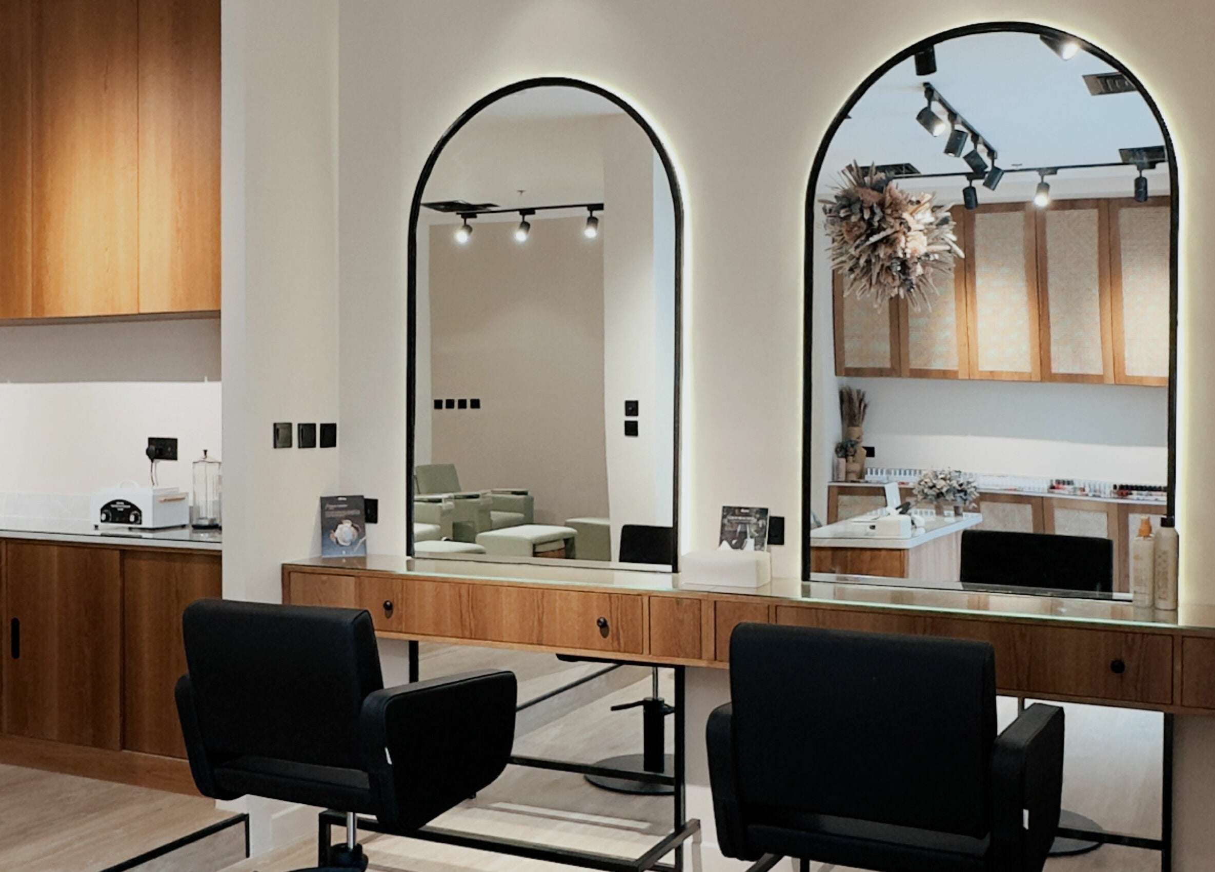 Modern salon setup at Snob Salon Arjan, دبي, دبي, AE featuring sleek wooden décor and stylish mirrors.