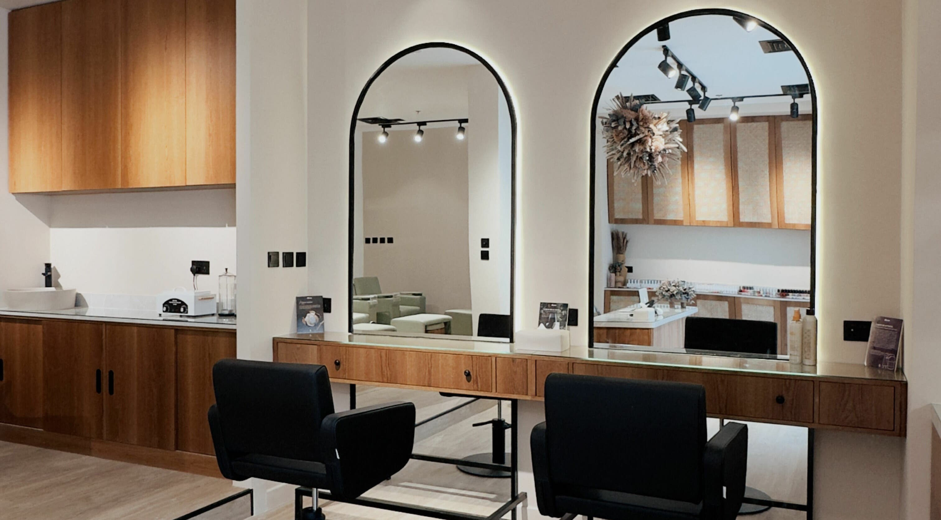 Modern salon setup at Snob Salon Arjan, دبي, دبي, AE featuring sleek wooden décor and stylish mirrors.