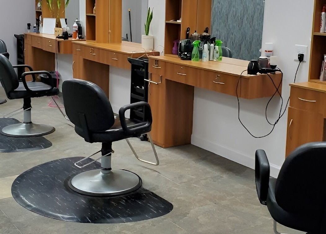 Modern salon chairs and stations at Illusions Salon Co in Round Lake, Illinois, US, showcasing stylish interior.
