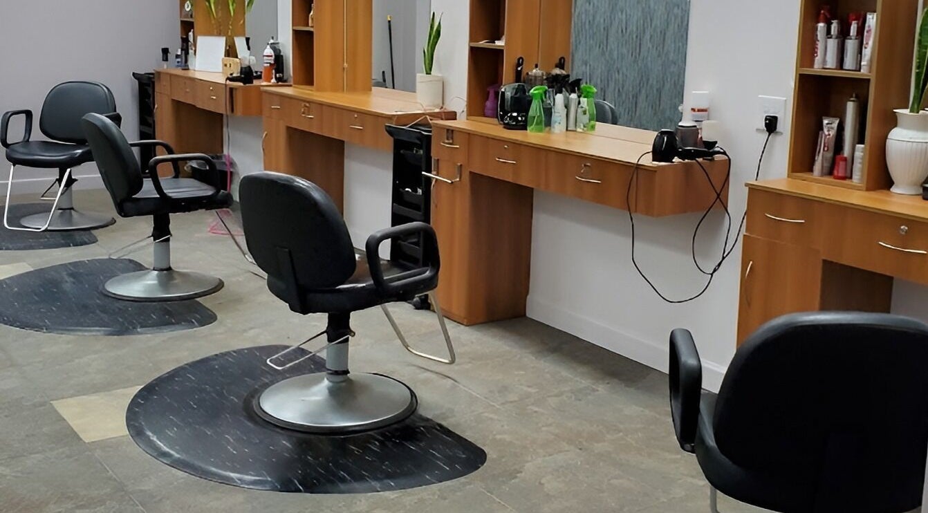 Modern salon chairs and stations at Illusions Salon Co in Round Lake, Illinois, US, showcasing stylish interior.