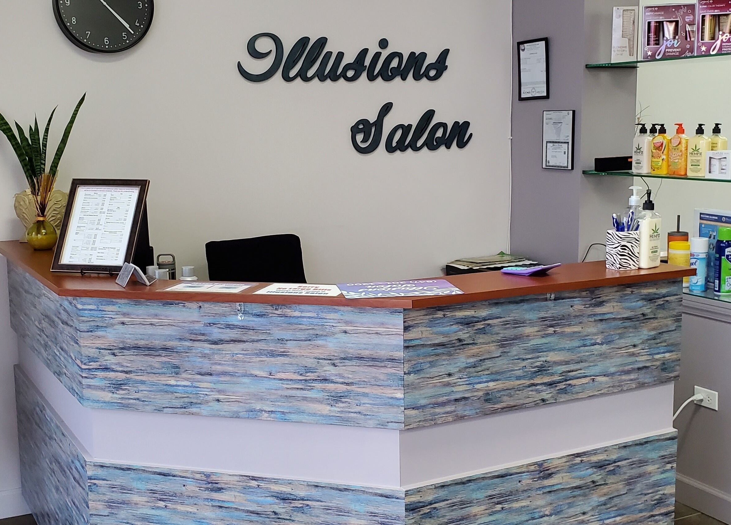 Reception desk at Illusions Salon Co in Round Lake, Illinois, US, with a stylish decor and product display.