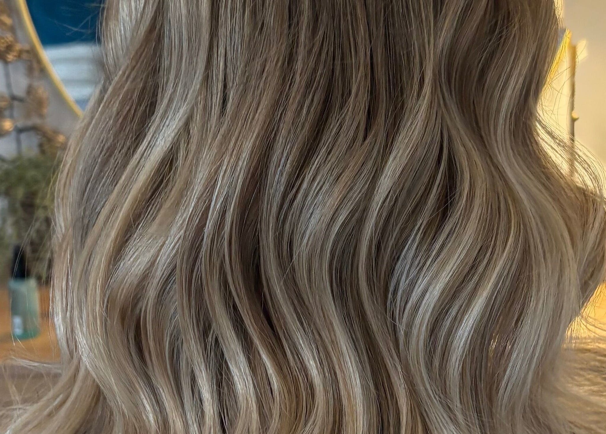 Glossy blonde waves styled at Hairbysarah salon in Chichester, England, GB.