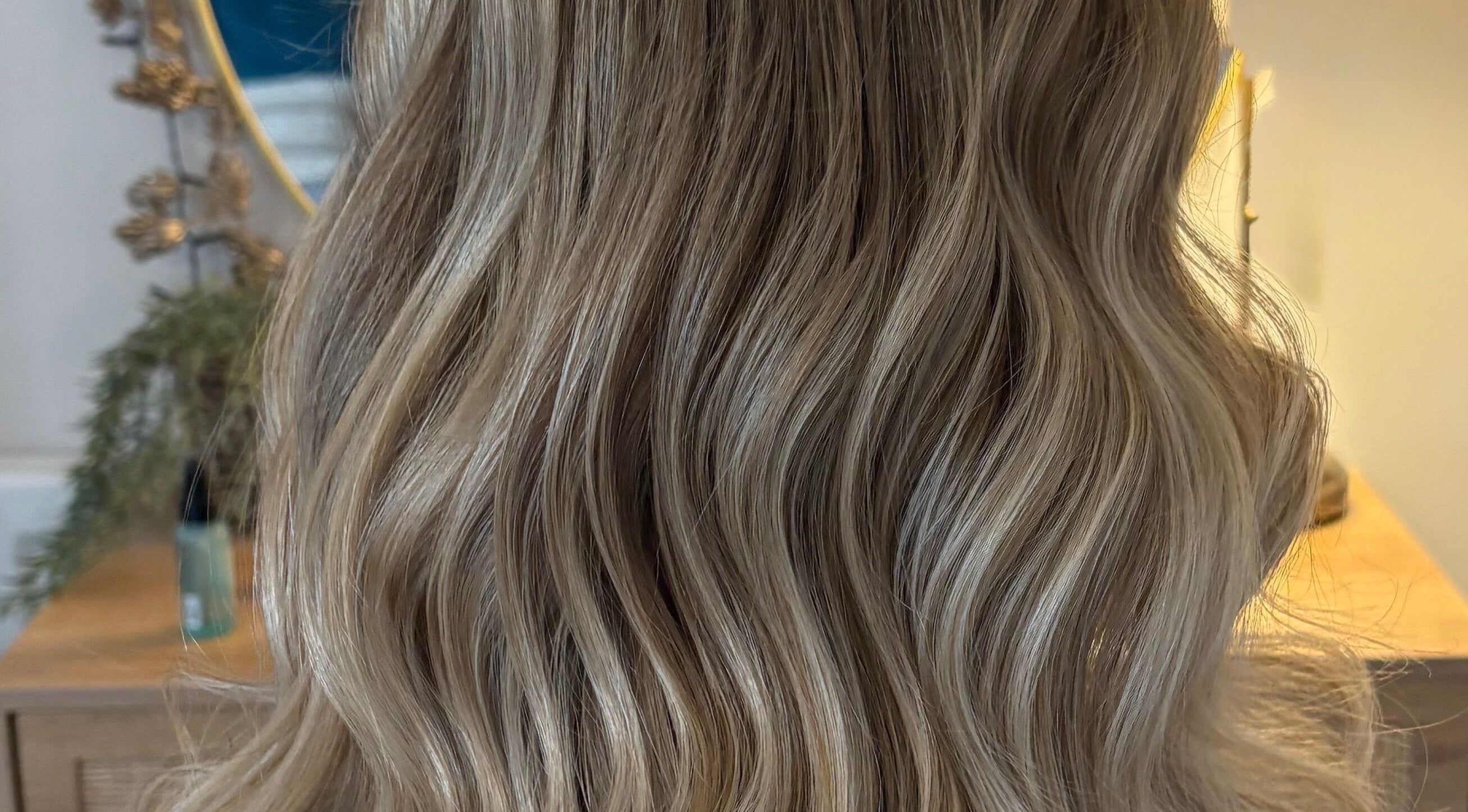 Glossy blonde waves styled at Hairbysarah salon in Chichester, England, GB.