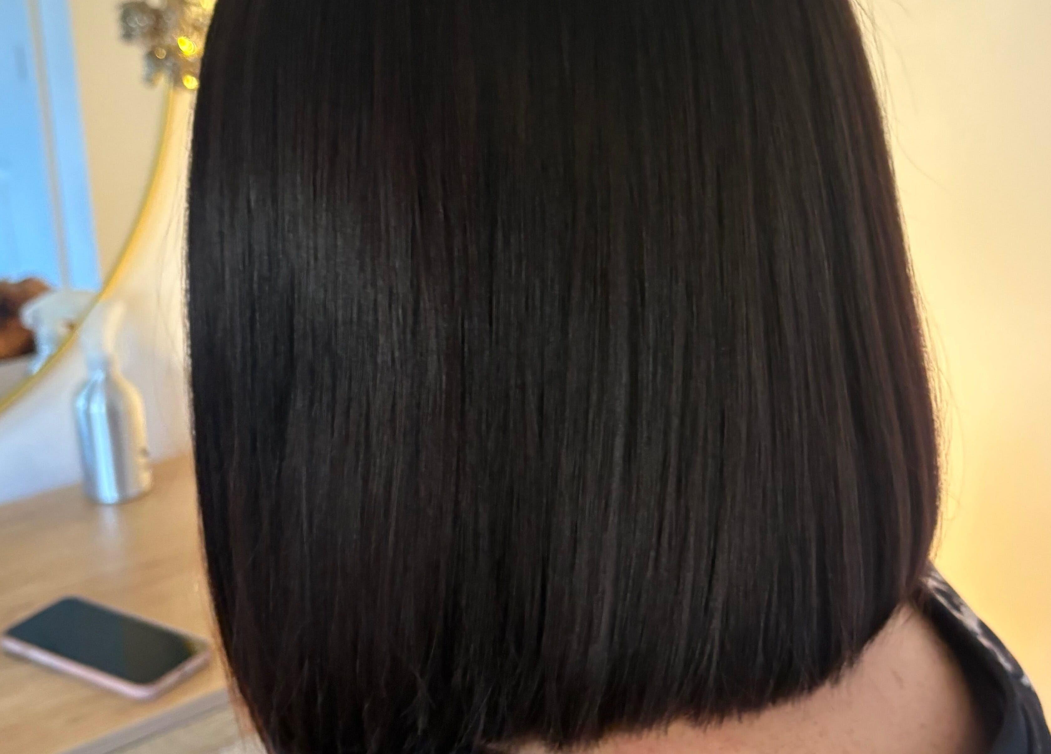 Sleek bob hairstyle at Hairbysarah in Chichester, England, GB. Modern salon interior visible in the mirror.