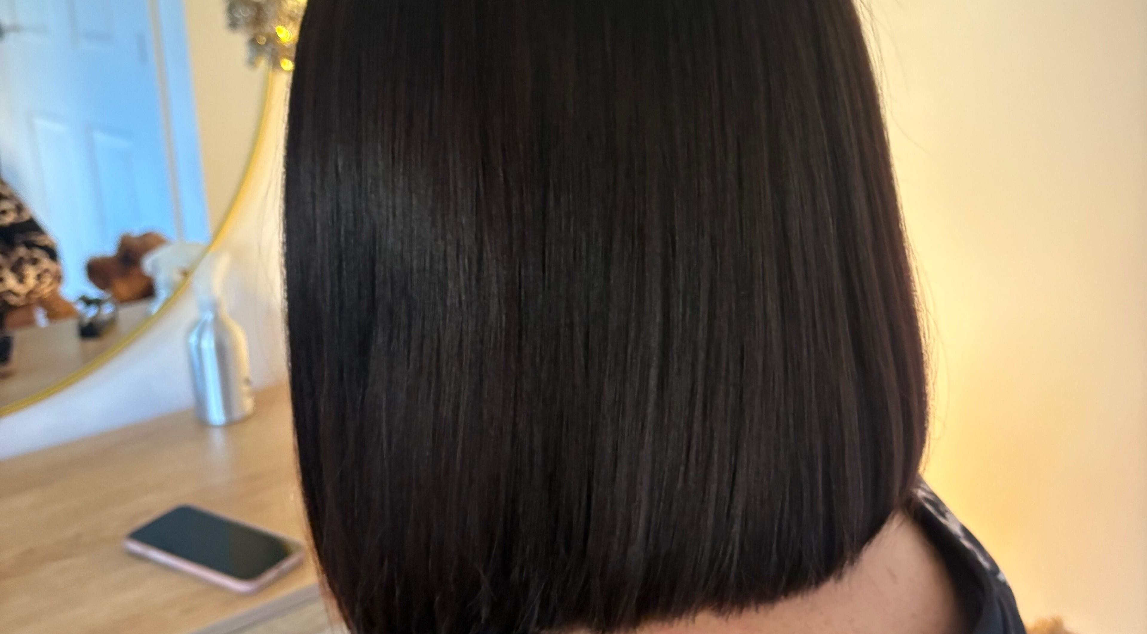 Sleek bob hairstyle at Hairbysarah in Chichester, England, GB. Modern salon interior visible in the mirror.